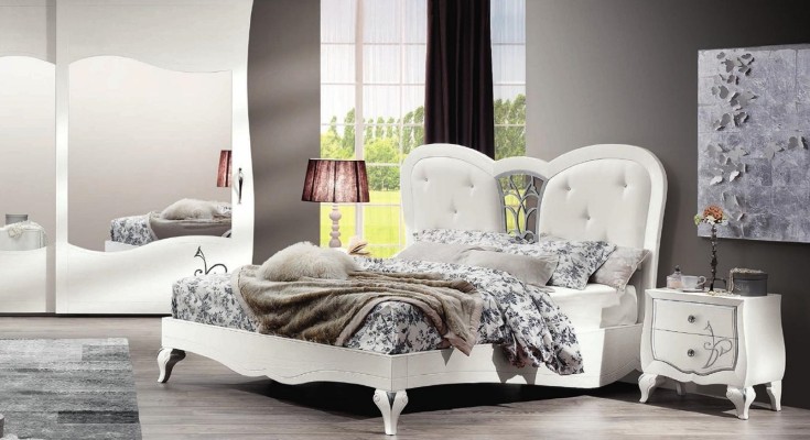 Белоснежная двуспальная кровать из массива дерева с элегантным узором на высоких ножках