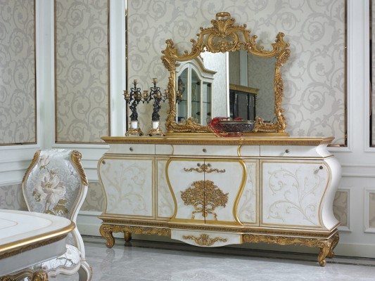Аристократичный комплект мебели выполненный в классическом стиле и состоящий из вместительного комода и зеркала с невероятными декоративными элементами золотого оттенка