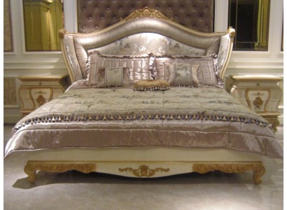 Великолепная кровать с потрясающим динамичным силуэтом изголовья и декоративными элементами золотого оттенка 