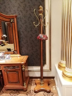 Превосходная вешалка для одежды выполненная в классическом стиле в теплом коричневом оттенке с декоративными элементами золотого цвета 