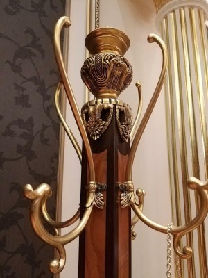 Превосходная вешалка для одежды выполненная в классическом стиле в теплом коричневом оттенке с декоративными элементами золотого цвета 